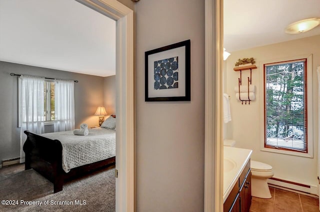 bedroom featuring tile patterned flooring and a baseboard heating unit