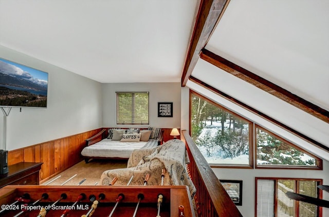 carpeted bedroom with wood walls and lofted ceiling with beams