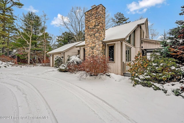 view of snow covered exterior featuring a garage