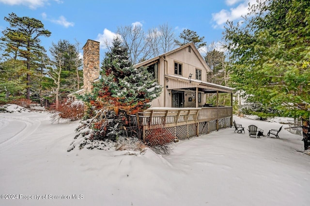 snow covered property with a wooden deck