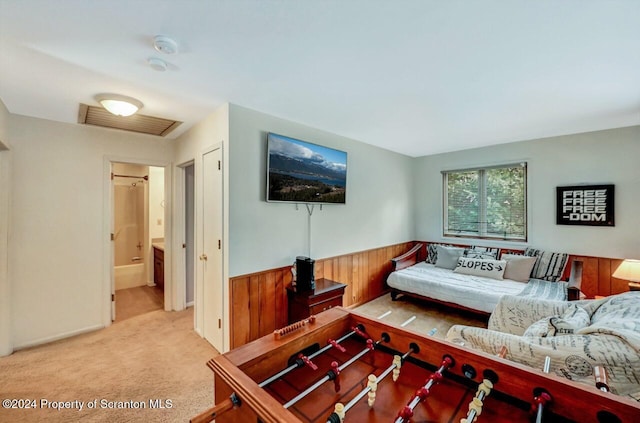 carpeted living room featuring wood walls