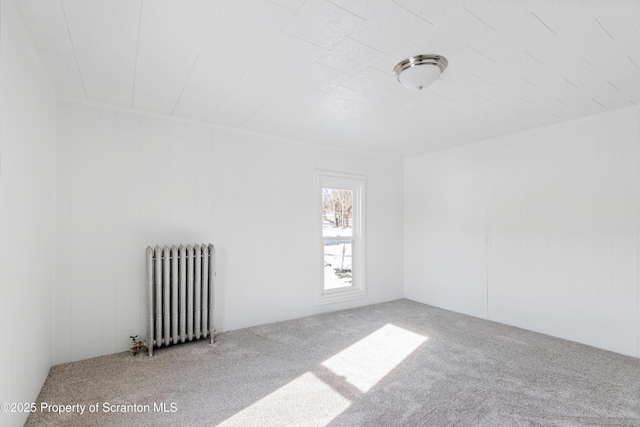 carpeted spare room with radiator heating unit