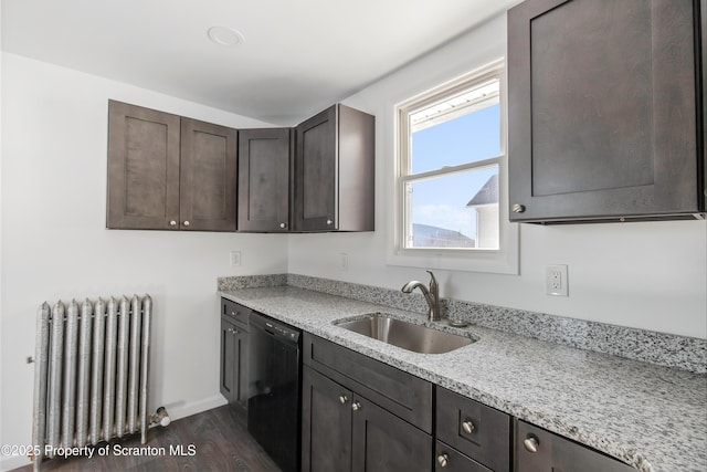 kitchen featuring sink, black dishwasher, dark hardwood / wood-style flooring, light stone counters, and radiator heating unit