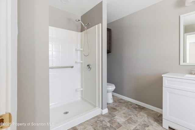 bathroom featuring vanity, toilet, and a shower