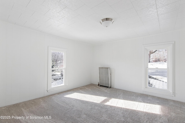 unfurnished room with carpet flooring and radiator