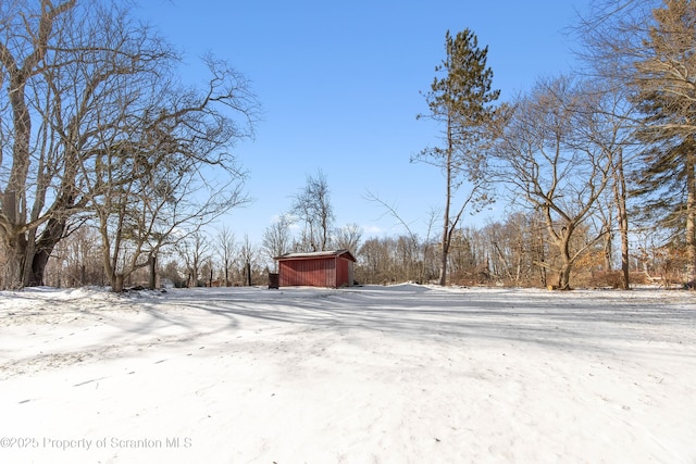 yard layered in snow featuring an outdoor structure