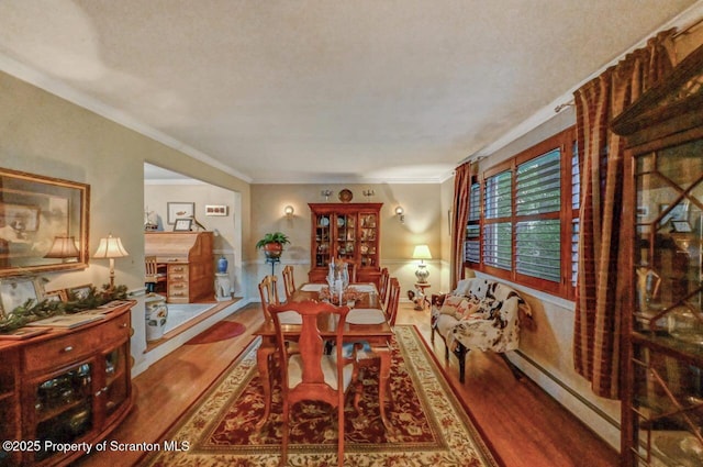 7 Lakeside Dr, Clarks Summit, PA 18411 - dining space with wood finished floors, a baseboard heating unit, and crown molding
