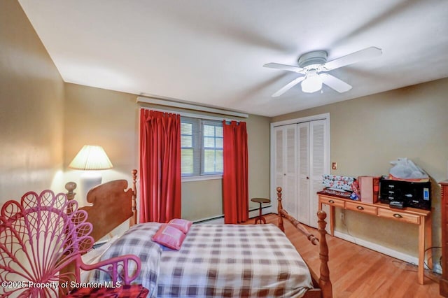 7 Lakeside Dr, Clarks Summit, PA 18411 - bedroom featuring a closet, wood finished floors, a baseboard radiator, a ceiling fan, and a baseboard heating unit
