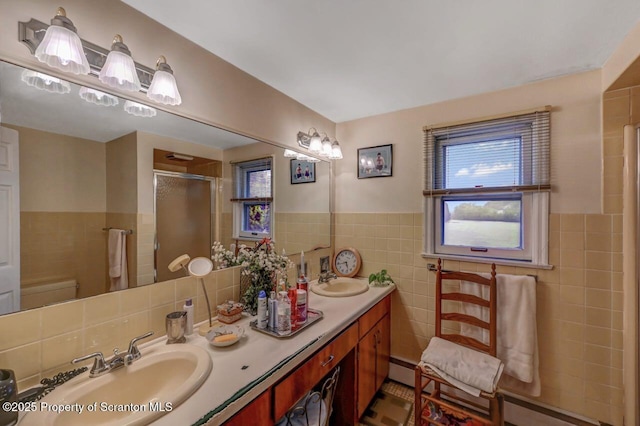 7 Lakeside Dr, Clarks Summit, PA 18411 - bathroom featuring tile walls, a stall shower, double vanity, a wainscoted wall, and a baseboard radiator