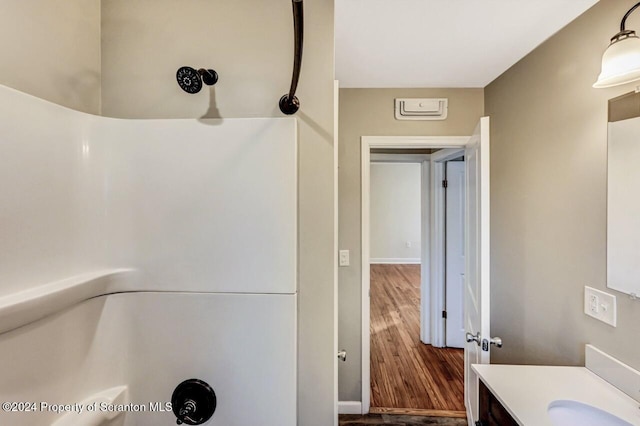 bathroom featuring walk in shower, vanity, and hardwood / wood-style flooring