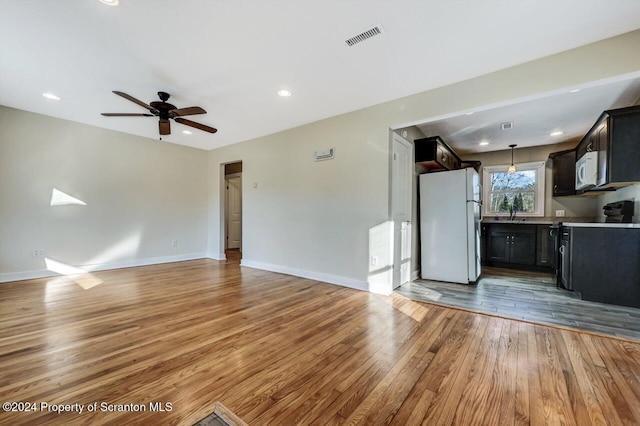 unfurnished living room with ceiling fan and wood-type flooring