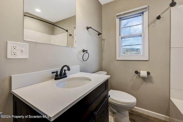 bathroom featuring hardwood / wood-style flooring, vanity, toilet, and walk in shower