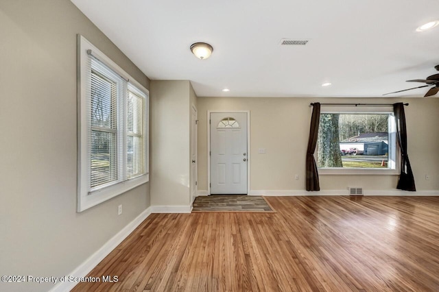 foyer entrance featuring ceiling fan, a healthy amount of sunlight, and hardwood / wood-style flooring