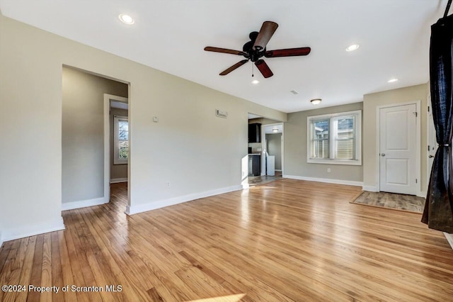 unfurnished living room featuring ceiling fan and light wood-type flooring