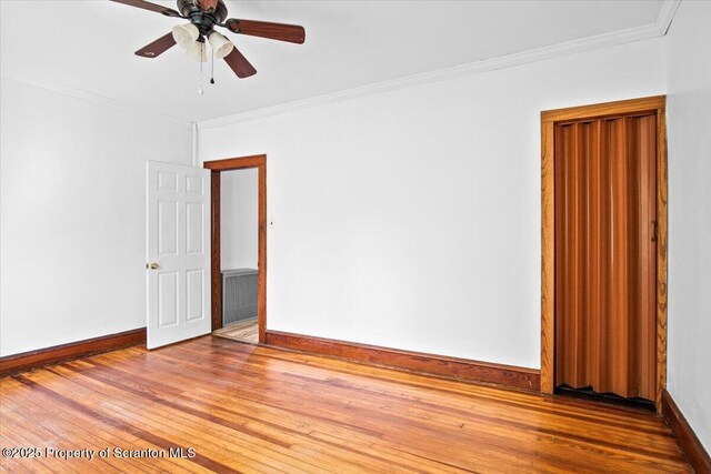 empty room featuring baseboards, ornamental molding, and wood finished floors