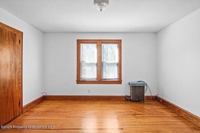 empty room featuring baseboards and light wood-style flooring