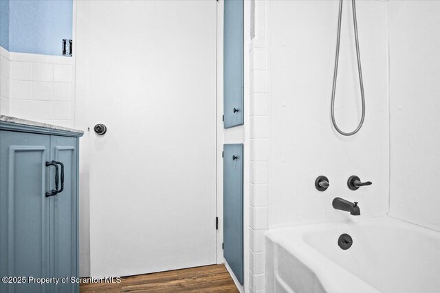 full bathroom featuring washtub / shower combination and wood finished floors