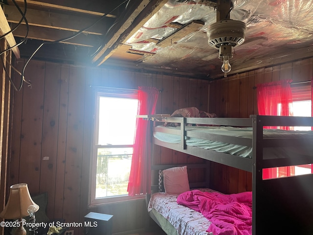 bedroom featuring wooden walls