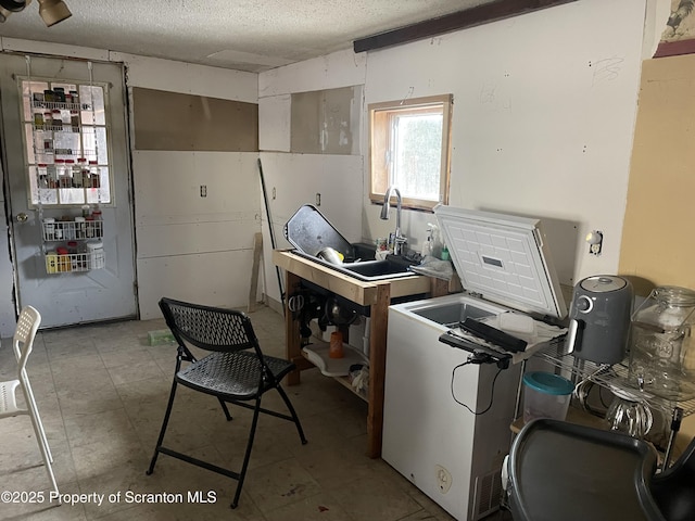 kitchen with a sink and a textured ceiling