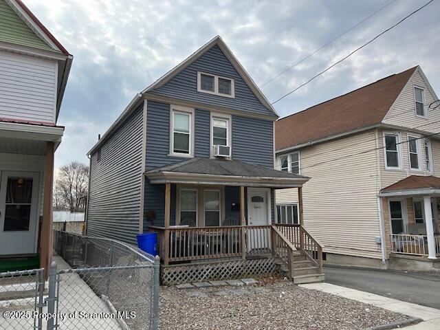 view of front of home with fence and a porch