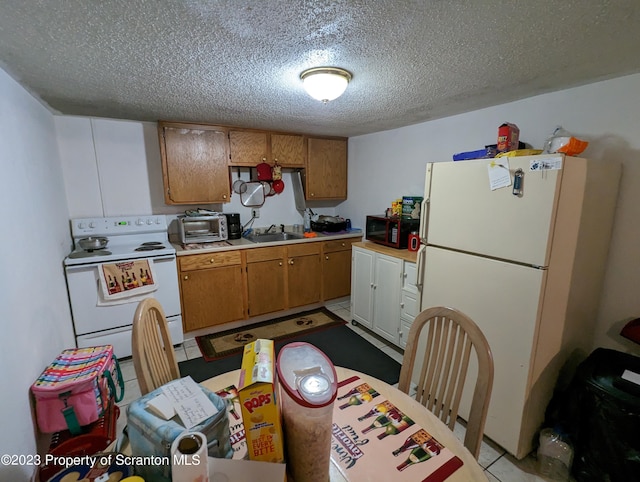 121 Sand St, Dunmore, PA 18510 - kitchen with white appliances, a textured ceiling, light countertops, brown cabinets, and light tile patterned floors