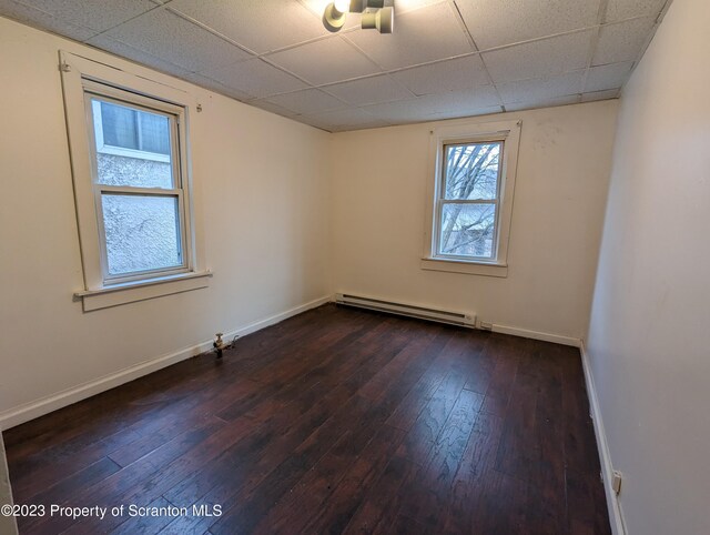 121 Sand St, Dunmore, PA 18510 - empty room featuring a baseboard heating unit, dark wood-style flooring, and a drop ceiling