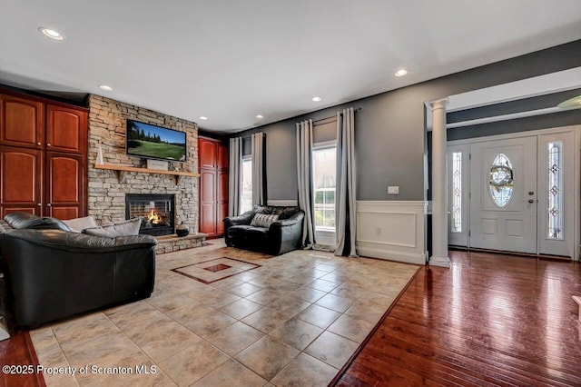 1015 Circle Green Dr Unit L 25, South Abington Twp, PA 18411 - living room with plenty of natural light, a decorative wall, a fireplace, ornate columns, and a wainscoted wall