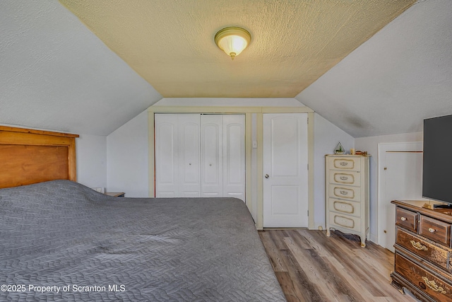 115 Marion St, Old Forge, PA 18518 - bedroom featuring wood finished floors, a textured ceiling, lofted ceiling, and a closet