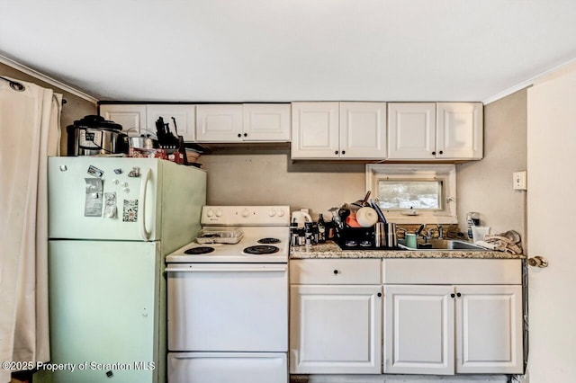 kitchen with white appliances, sink, and white cabinets