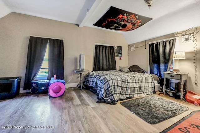 bedroom featuring hardwood / wood-style floors and lofted ceiling with beams