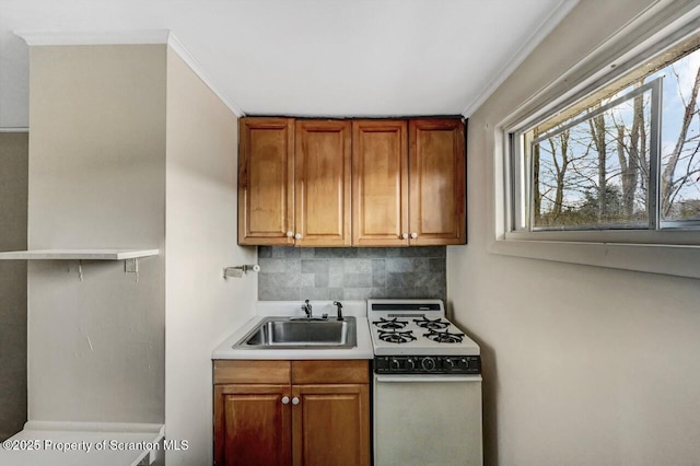 kitchen featuring sink, tasteful backsplash, crown molding, and white gas range oven