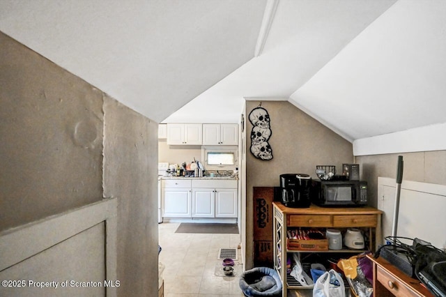 interior space with white cabinets and lofted ceiling