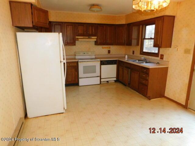 kitchen with sink, white appliances, and an inviting chandelier