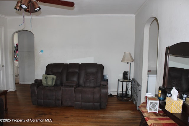 living room with arched walkways, wood finished floors, and ornamental molding