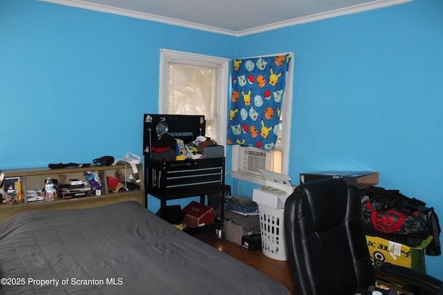 bedroom featuring wood finished floors and ornamental molding