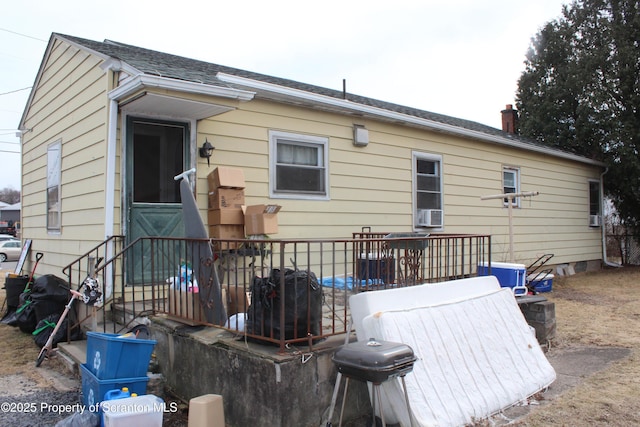 rear view of house featuring a chimney