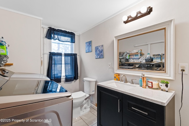 bathroom featuring washing machine and dryer, vanity, and toilet