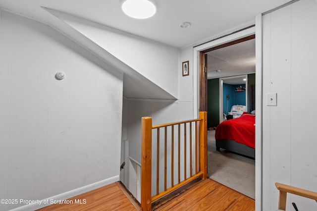 hall with light hardwood / wood-style floors and a textured ceiling