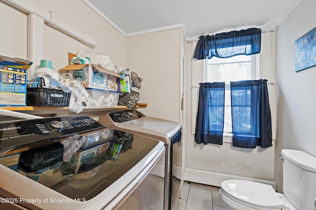 washroom with ornamental molding and washer and dryer