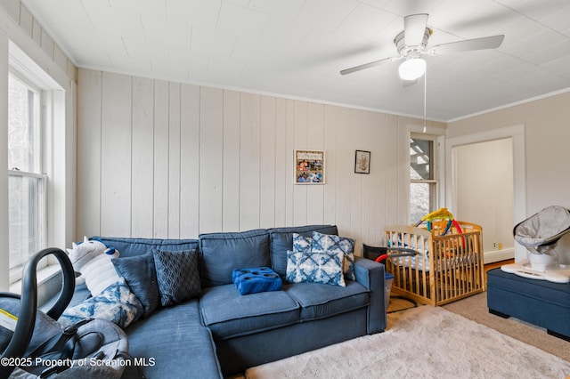 carpeted living room featuring crown molding and ceiling fan