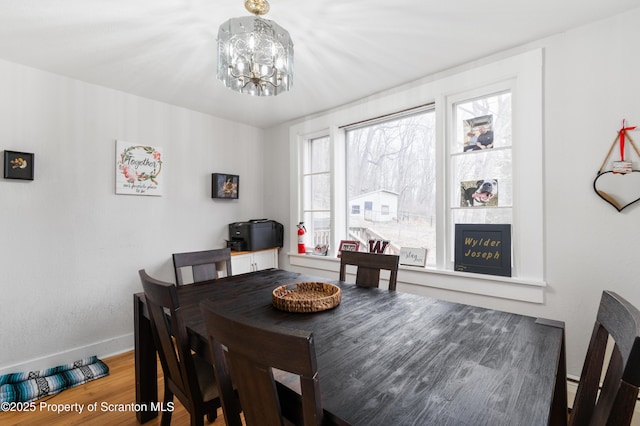 dining space featuring an inviting chandelier, hardwood / wood-style flooring, and a fireplace