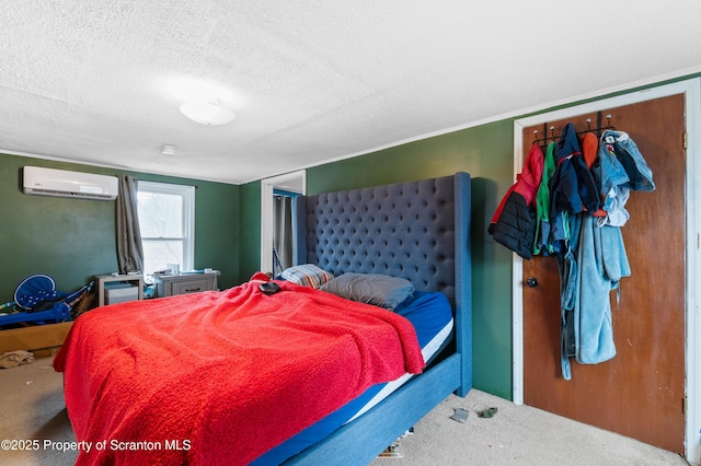 bedroom featuring a wall unit AC, a textured ceiling, and carpet flooring