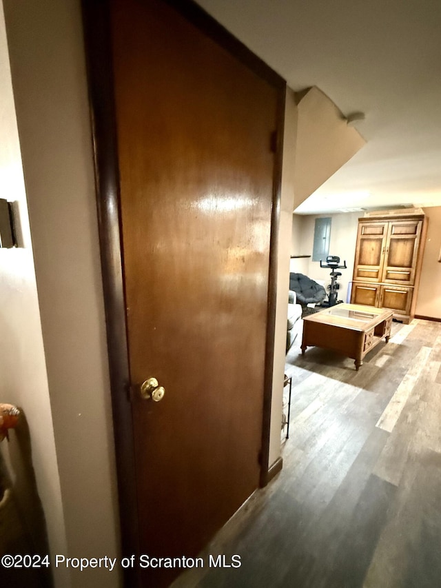 corridor with light wood-type flooring and electric panel