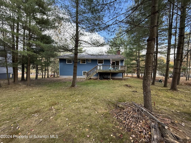 back of property with a lawn and a wooden deck