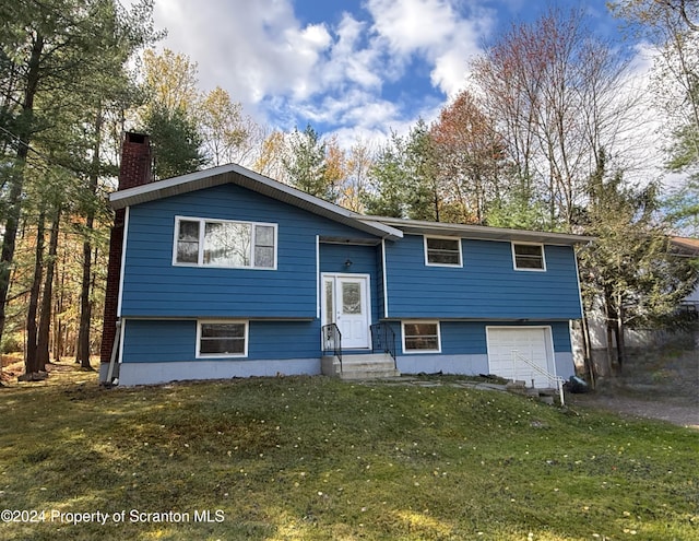 bi-level home with a front yard and a garage