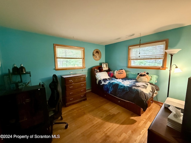 bedroom with light wood-type flooring and a baseboard radiator