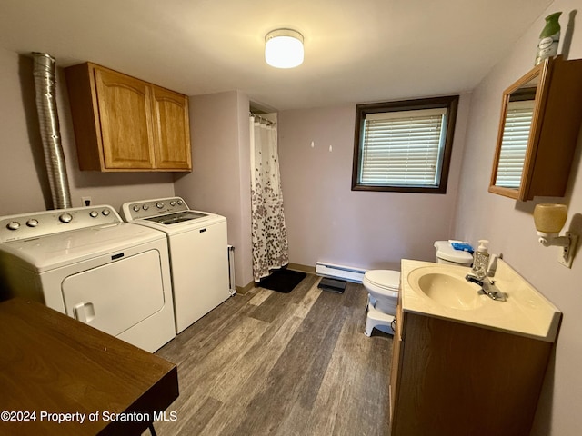 clothes washing area featuring separate washer and dryer, sink, dark wood-type flooring, and a baseboard heating unit