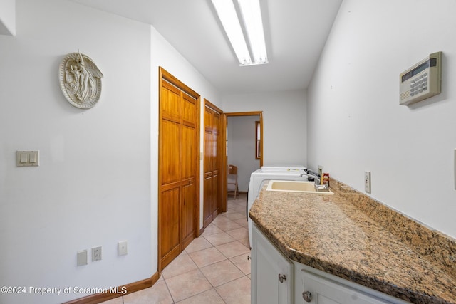 laundry room with hookup for a washing machine, sink, light tile patterned floors, and cabinets