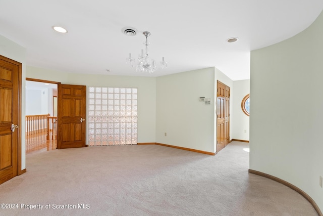 unfurnished room featuring light carpet and a notable chandelier