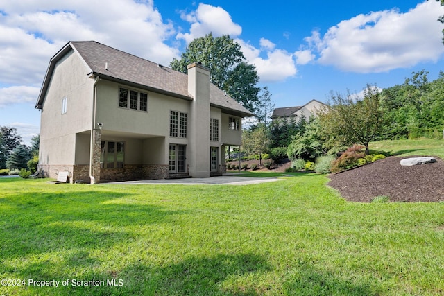 133 Glenmaura Dr, Moosic, PA 18507 - back of property with a lawn, a chimney, and stucco siding